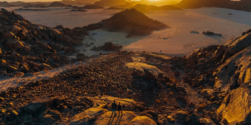 the sun is setting over a desert landscape
